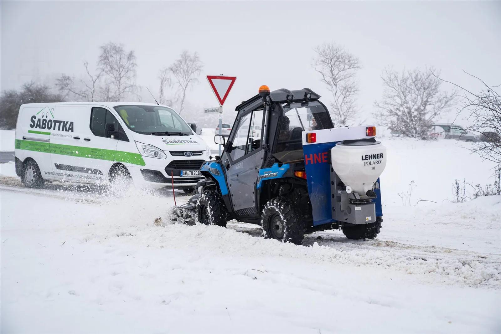Mitarbeiter beim Winterdienst auf einem geräumten Gehweg